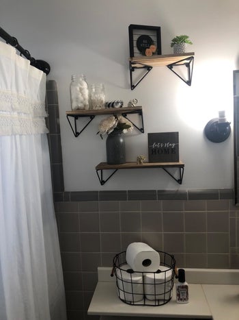 reviewer pic of the three shelves above a counter in a bathroom