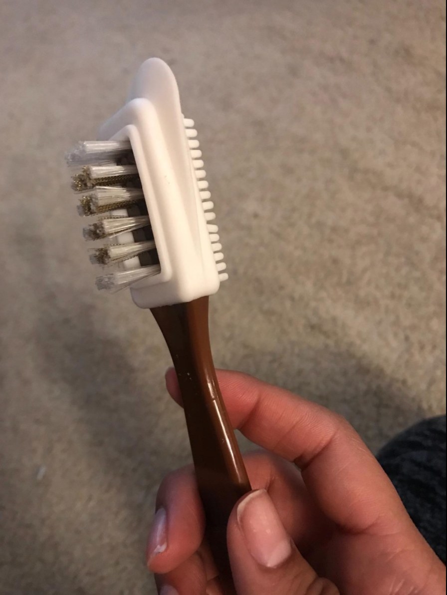 the reviewer holding the four way leather brush