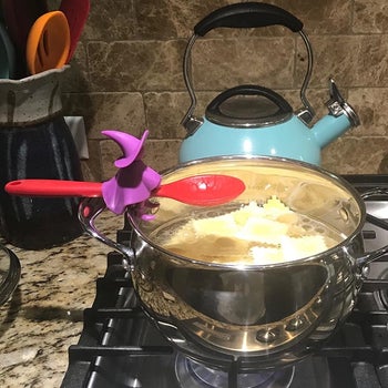 the product holding another reviewer's spoon over a pot