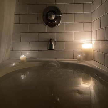 reviewer's bath tub filled to the brim because of the cover over the drainage spot