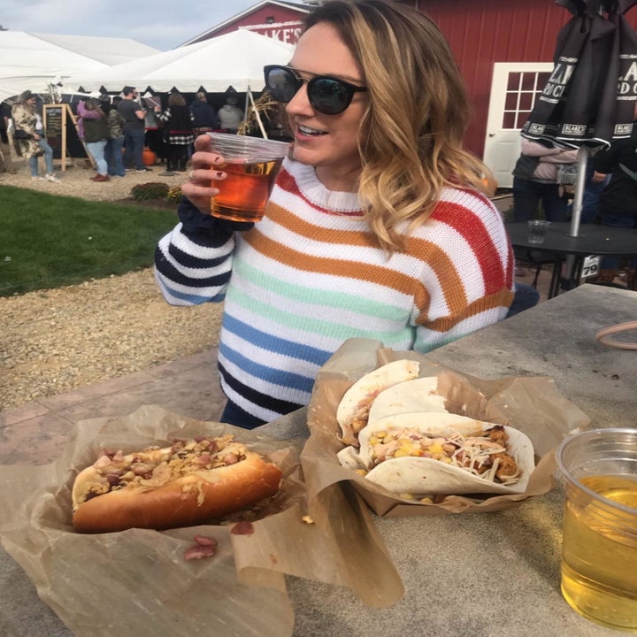 a reviewer in the striped rainbow sweater