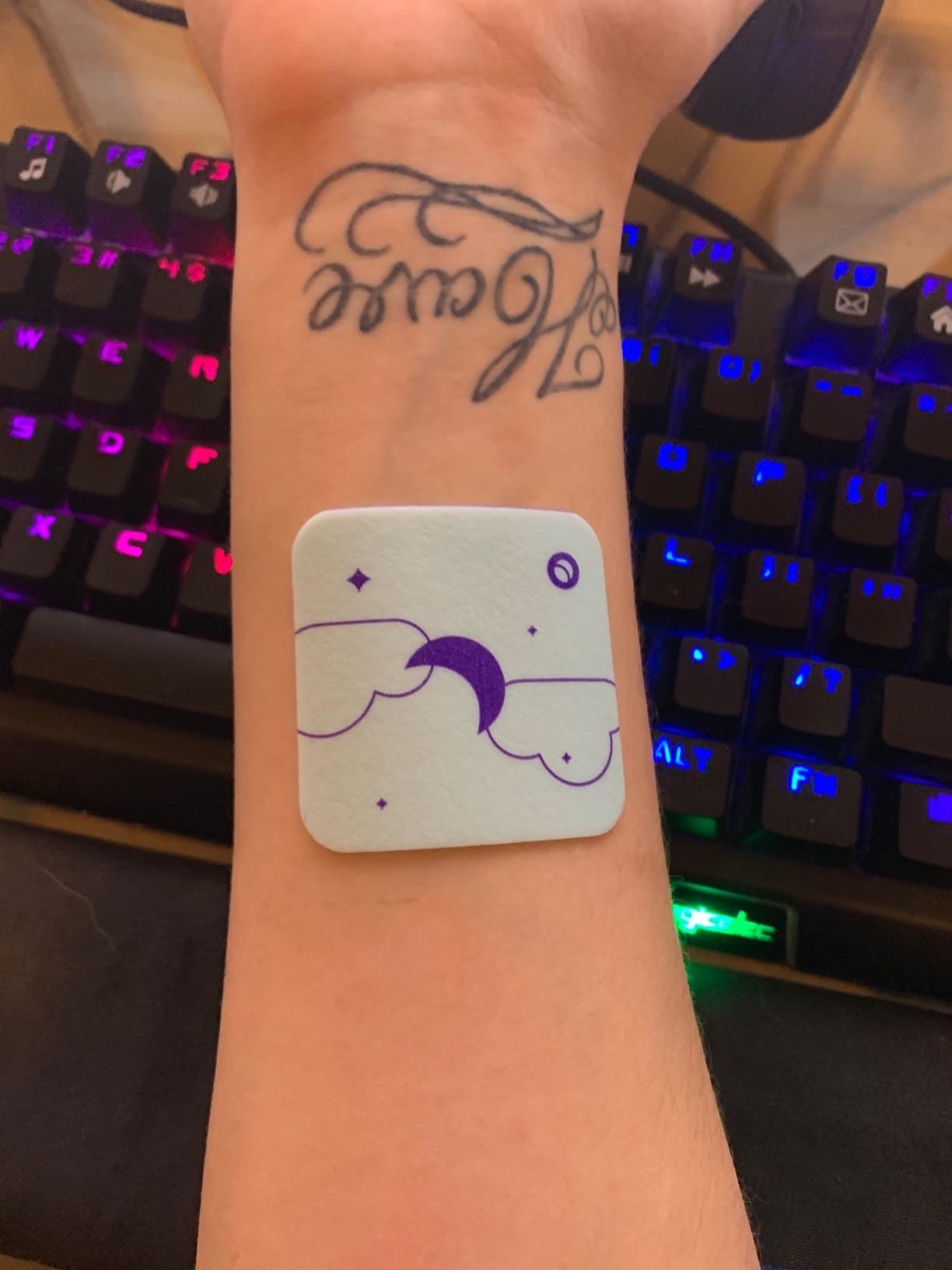 Reviewer&#x27;s arm with sticker on it
