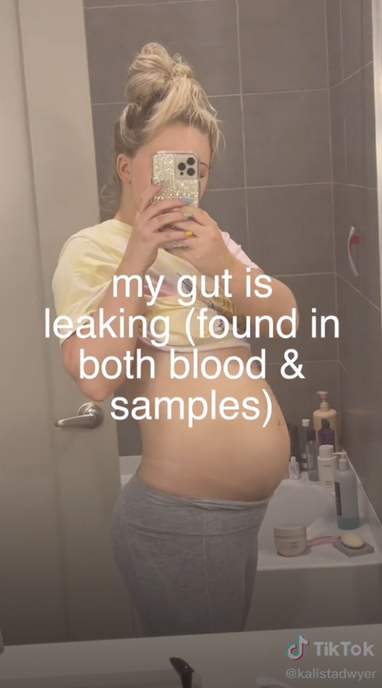 A mirror selfie of Kalista with the caption &quot;my gut is leaking (found in both blood &amp;amp; samples)&quot;