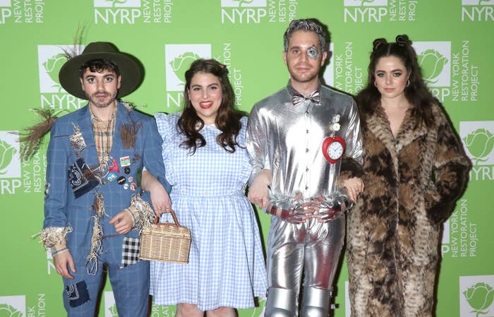 The couple and Beanie Feldstein posing in The Wizard of Oz Halloween costumes on a red carpet