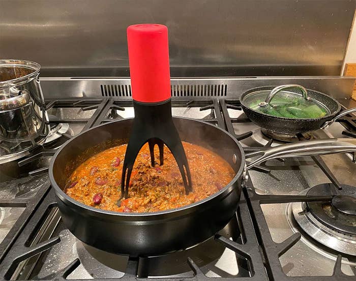 red stirrer mixing up a stew on the stove