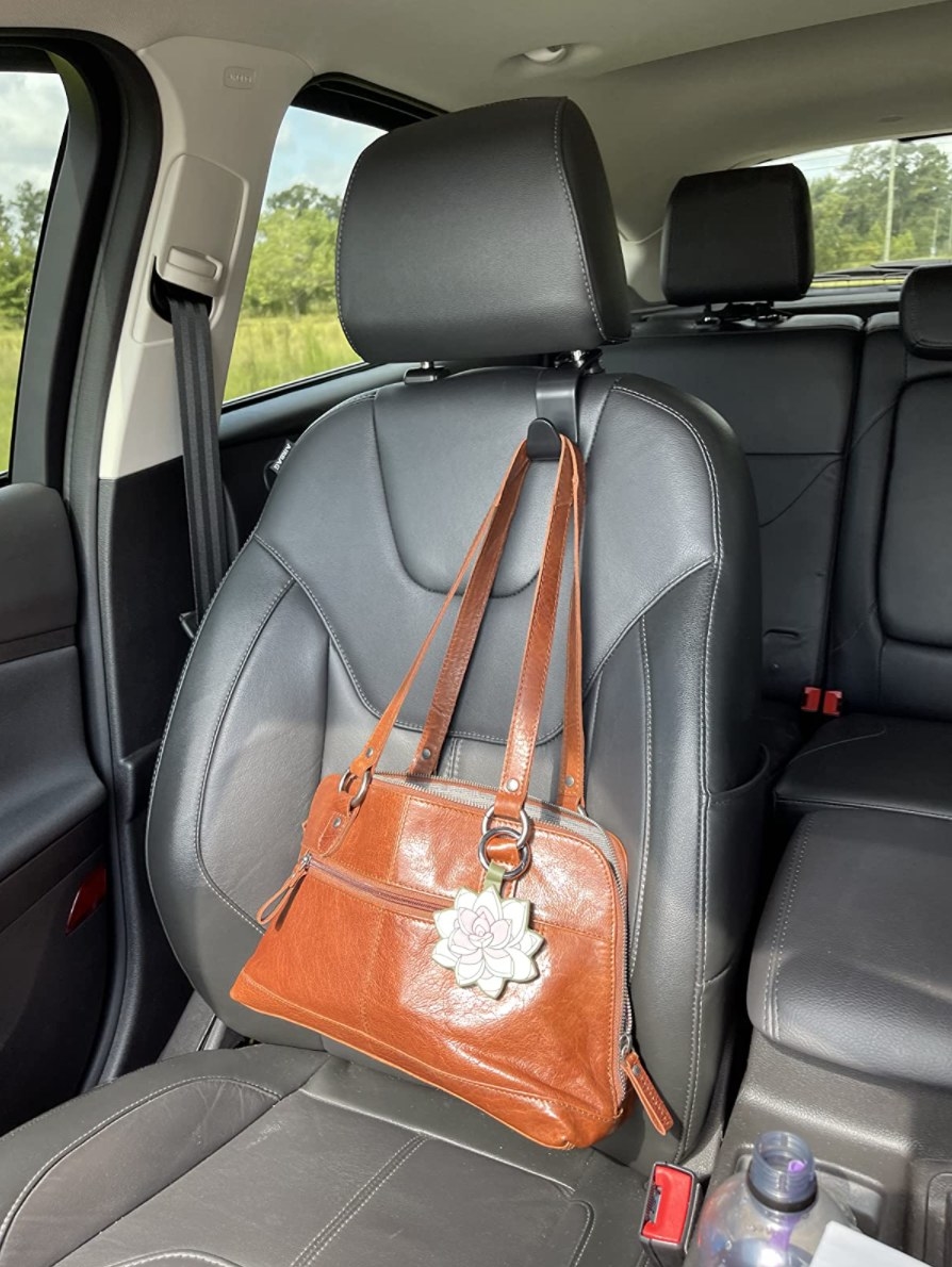 the car seat coat hook holding the reviewer&#x27;s orange handbag