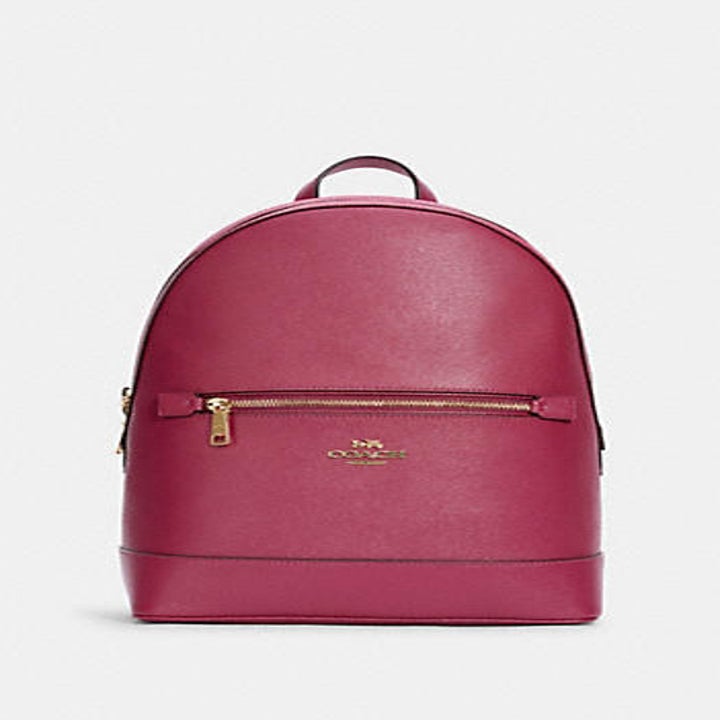 a rose pink Coach backpack with gold zippers