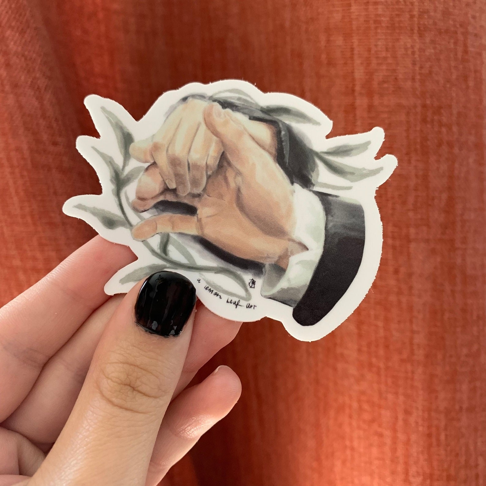The sticker with a piece of greenery and darcy&#x27;s hand flexed