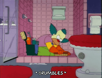 A cartoon clown angrily scrubs a bathroom