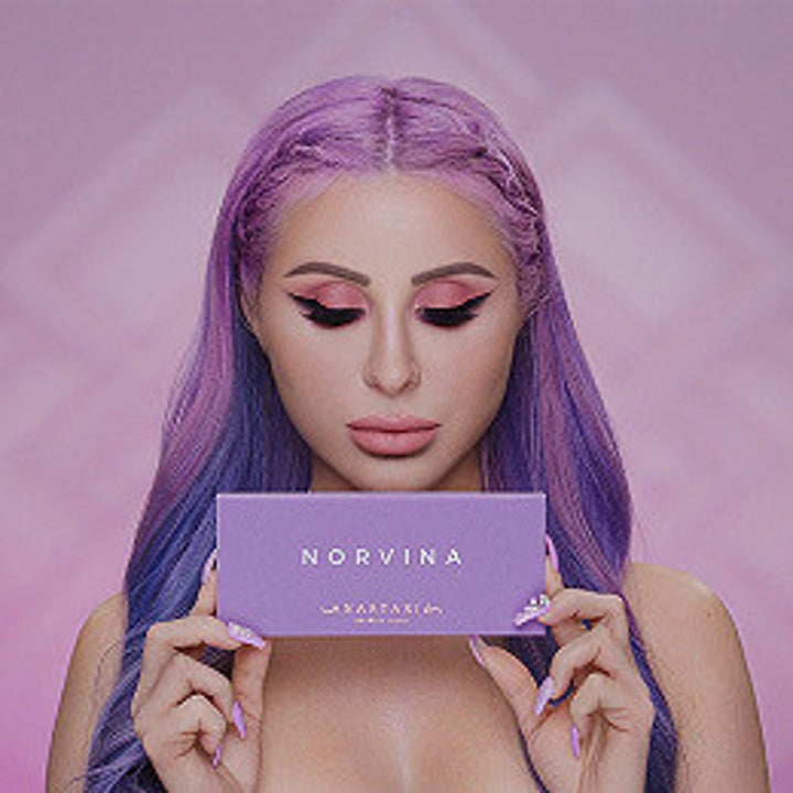 model holds purple Anastasia Beverly Hills eyeshadow palette