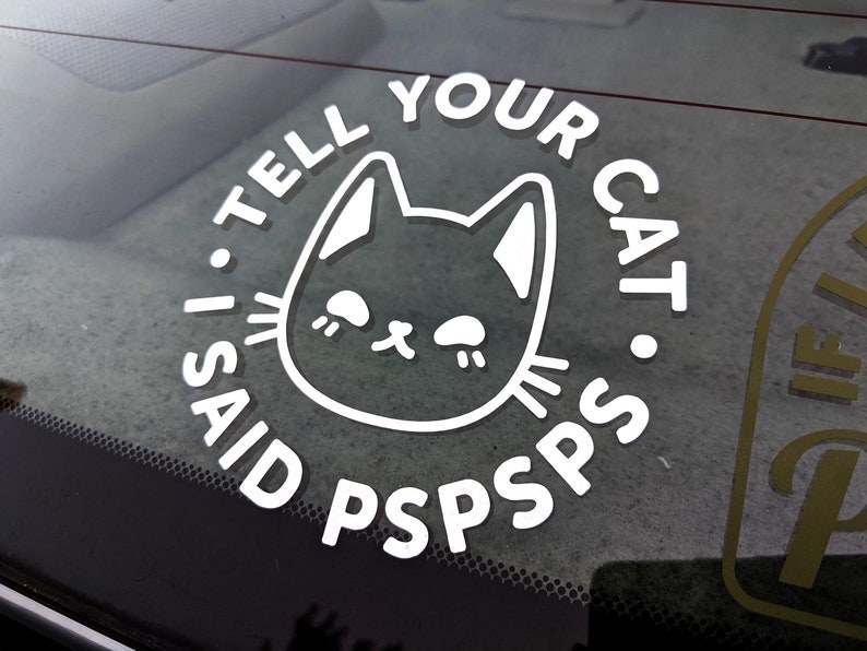 decal on a window that says "tell your cat i said pspsps" in a circle surrounding an illustration of a cat