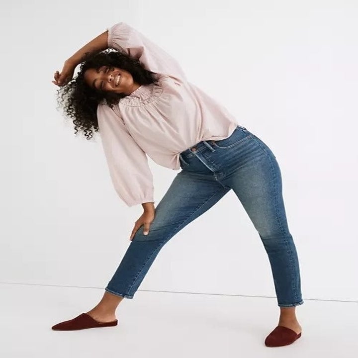 model in dark blue high-rise Perfect Vintage Jeans and pink blouse