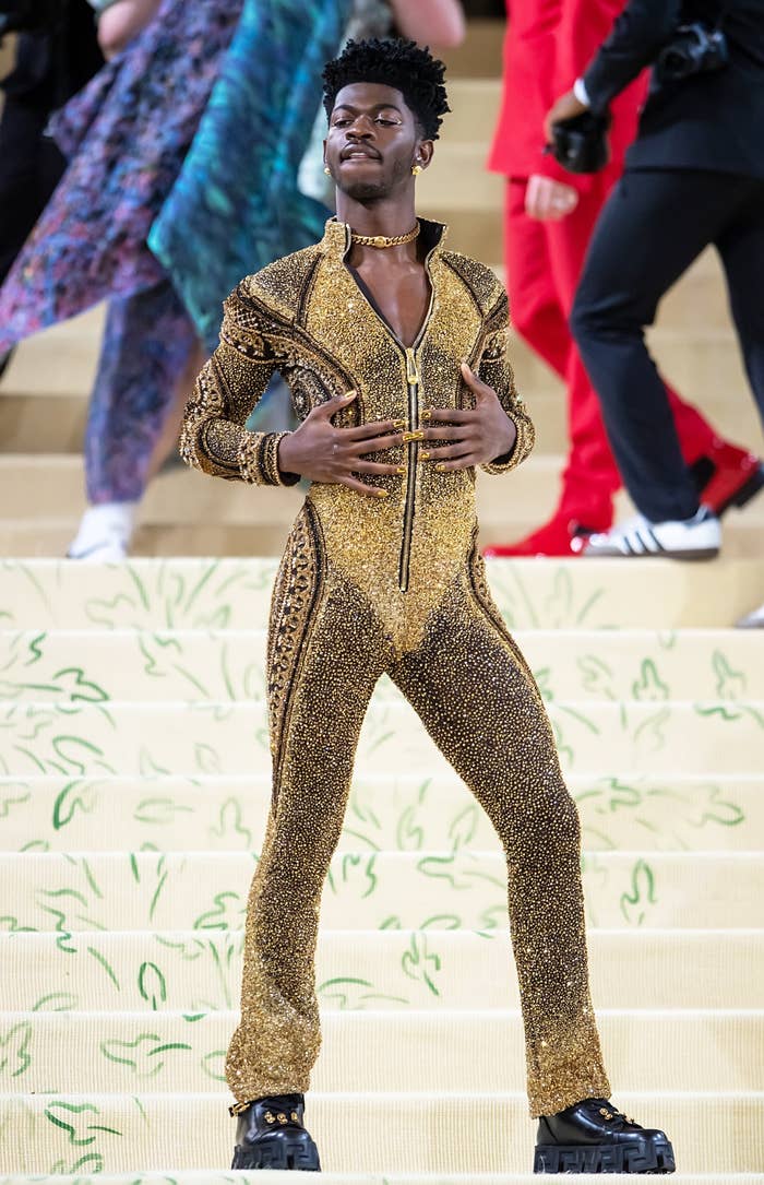 Lil Nas X posing at the 2021 Met Gala in a shimmering jumpsuit