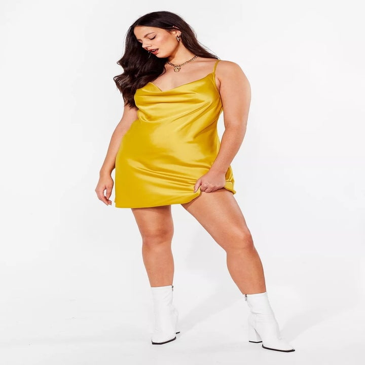 model in yellow strappy mini dress and white booties