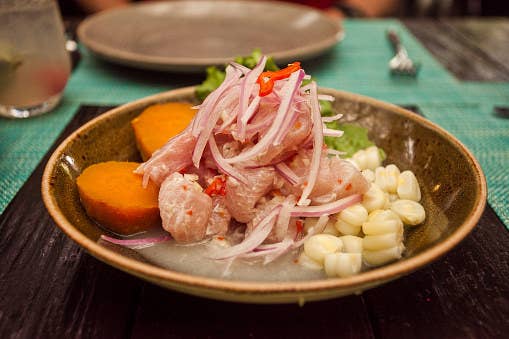 Peruvian ceviche with corn, fish, onions, and sweet potato.