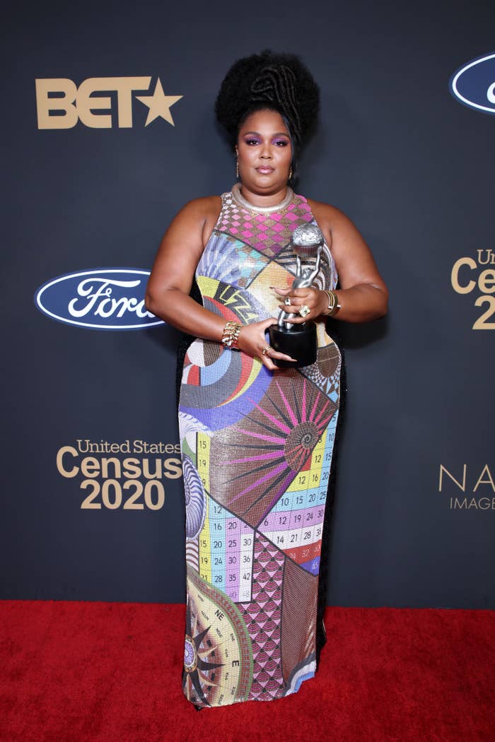 Lizzo posing with her NAACP Image award on the red carpet