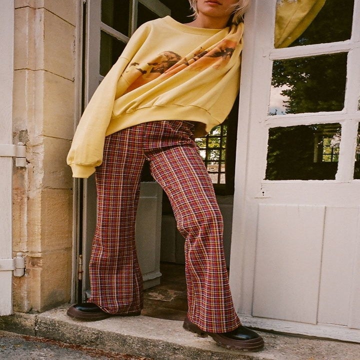 model wearing the pants in red, purple, and yellow plaid 