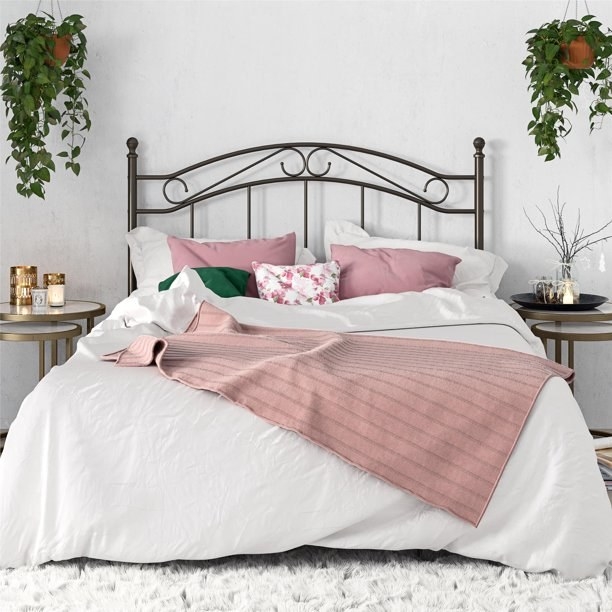 the headboard attached to a bed frame with pink and white bedding on it