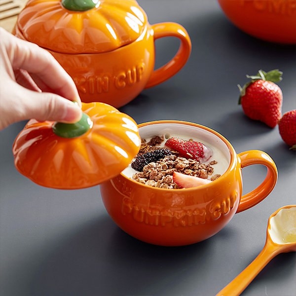 A yogurt parfait in the orange pumpkin bowl with a handle and matching top