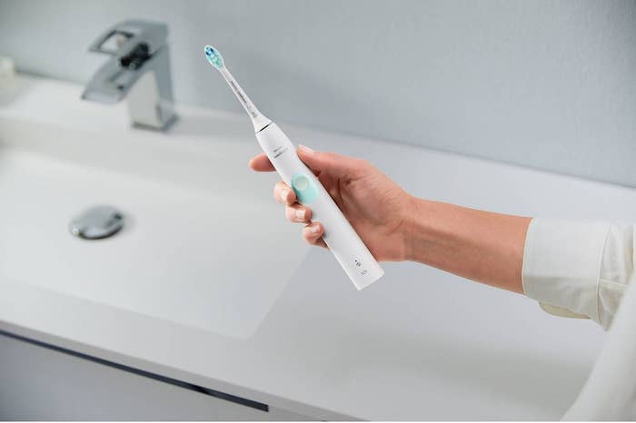 a model holding the toothbrush
