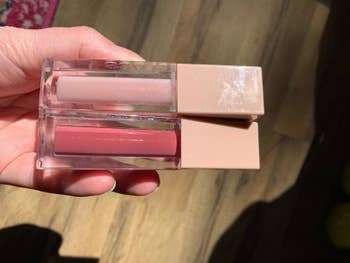 Reviewer showing two bottles of lip gloss
