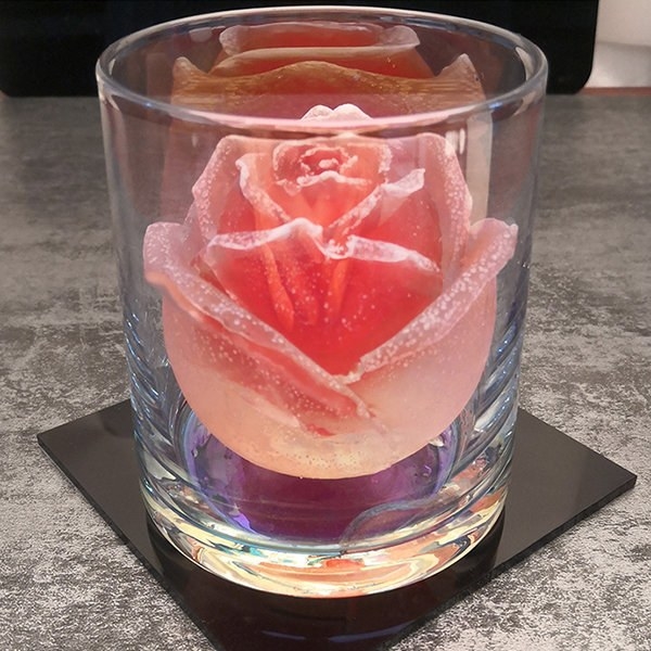 A rose-shaped ice cube from the mold in a glass