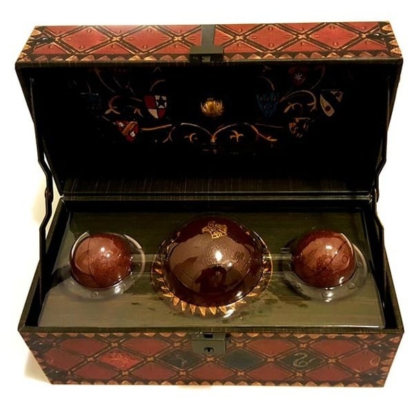 The Quidditch set with one quaffle and two Bludgers inside a wooden trunk