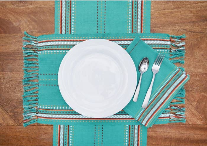 the southwestern style teal striped tasseled placemats with a white plate on top