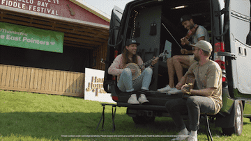 band playing banjo guitar and violin in the back of a van