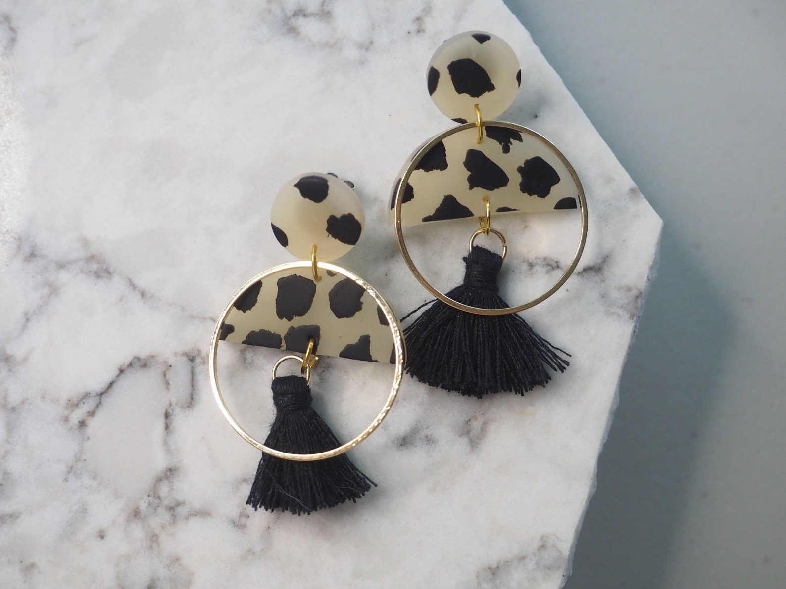 cow print clay earrings with hoop and tassel design