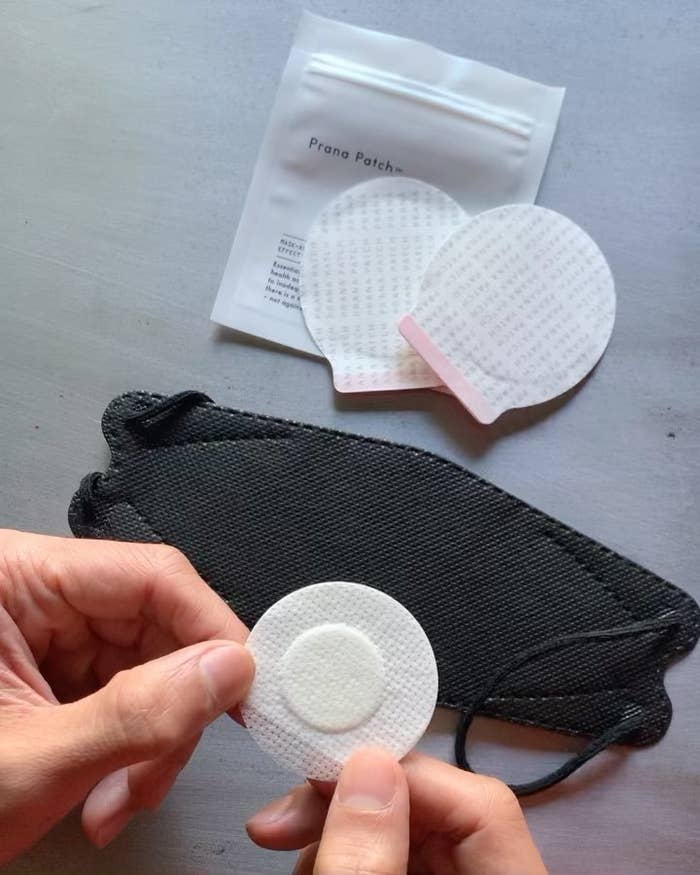 A person holding one of the aromatherapy patches in their hands