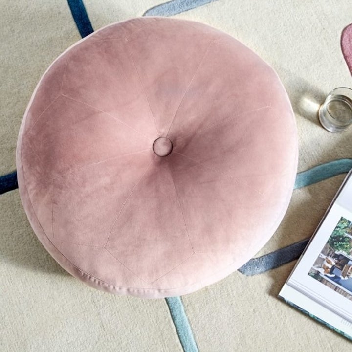the pink floor pillow on a carpet