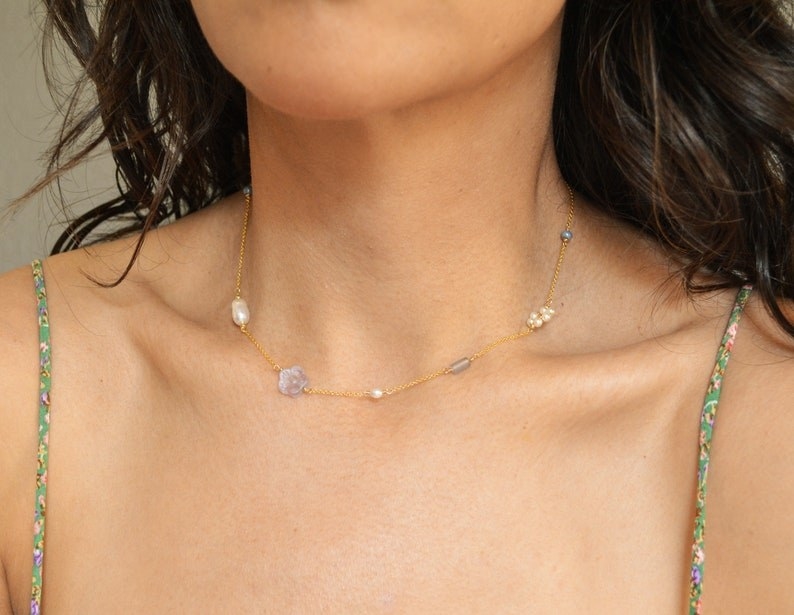 model with minimalist necklace with gold tone chain and white pearls and blue glass beads