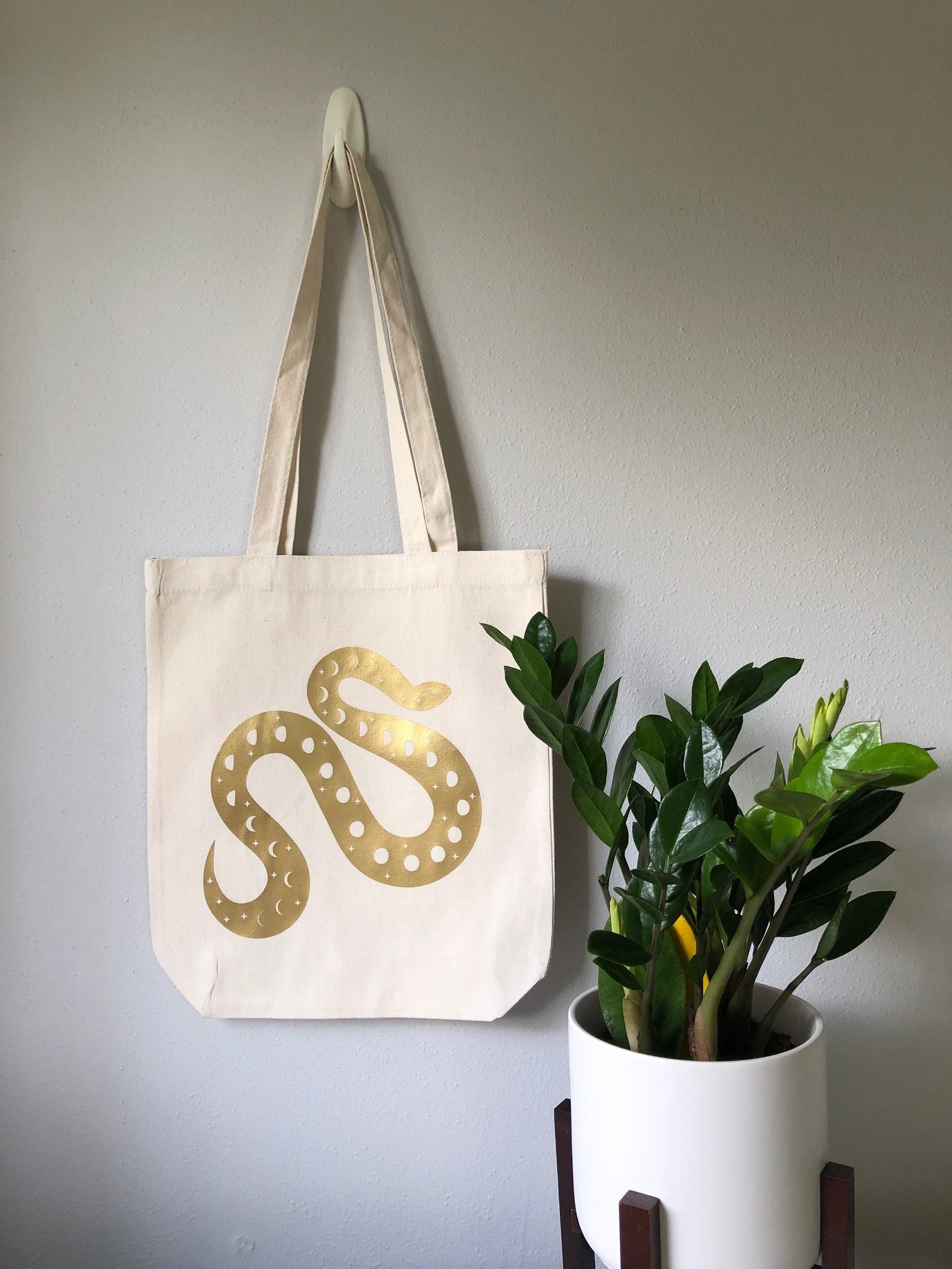 tote bag with gold snake pattern on it