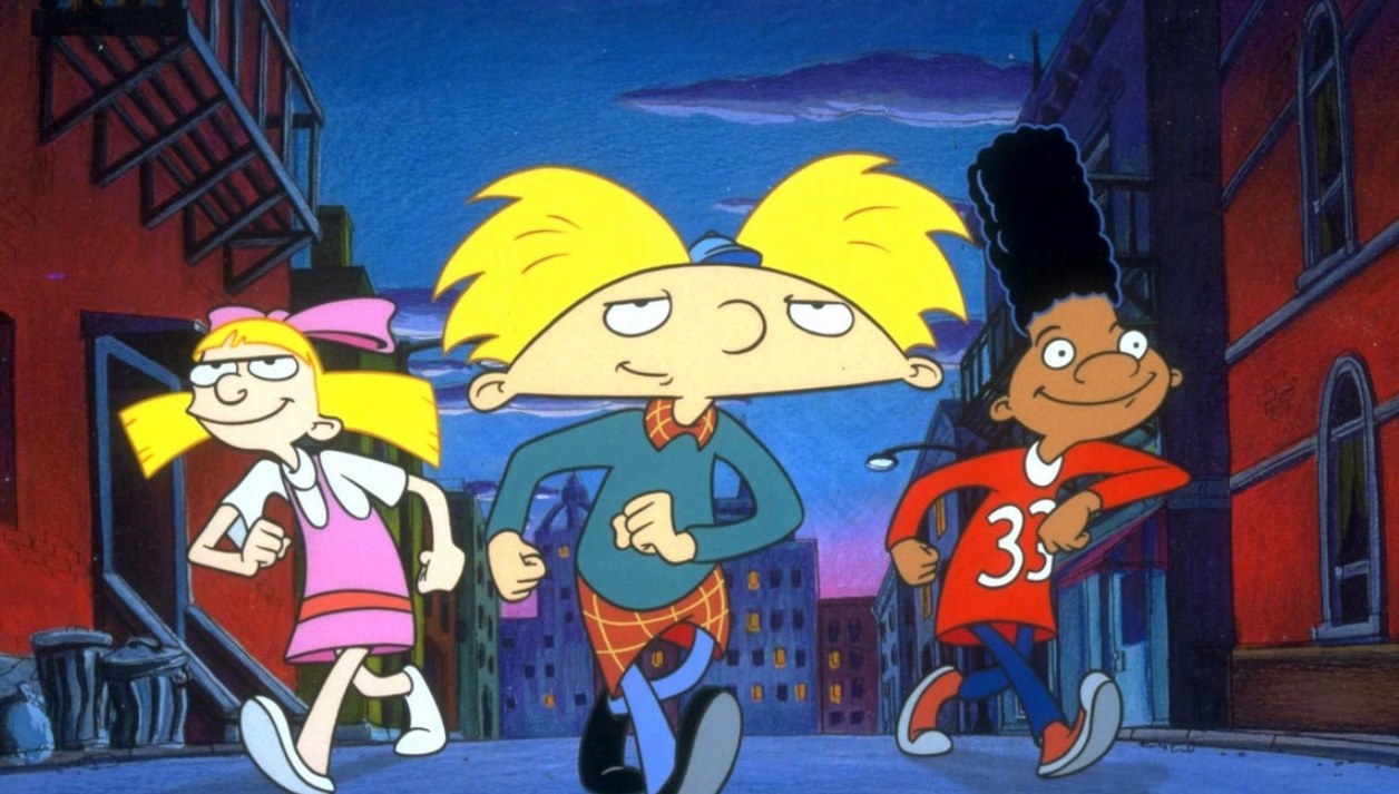 Arnold, Helga and Gerald walk through a city street smiling