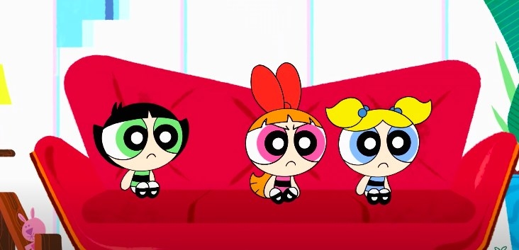 The Powerpuff girls sit on a red couch