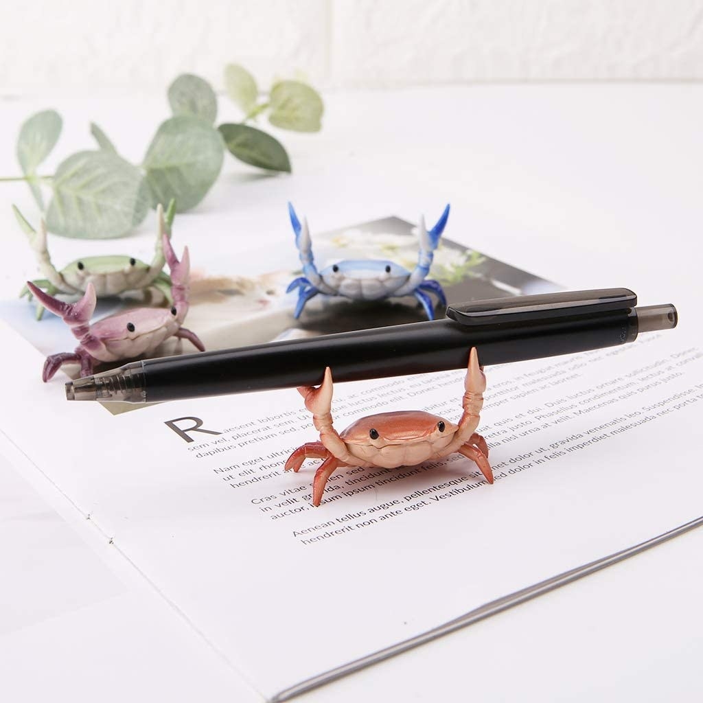 crabs with arms up to hold a pen