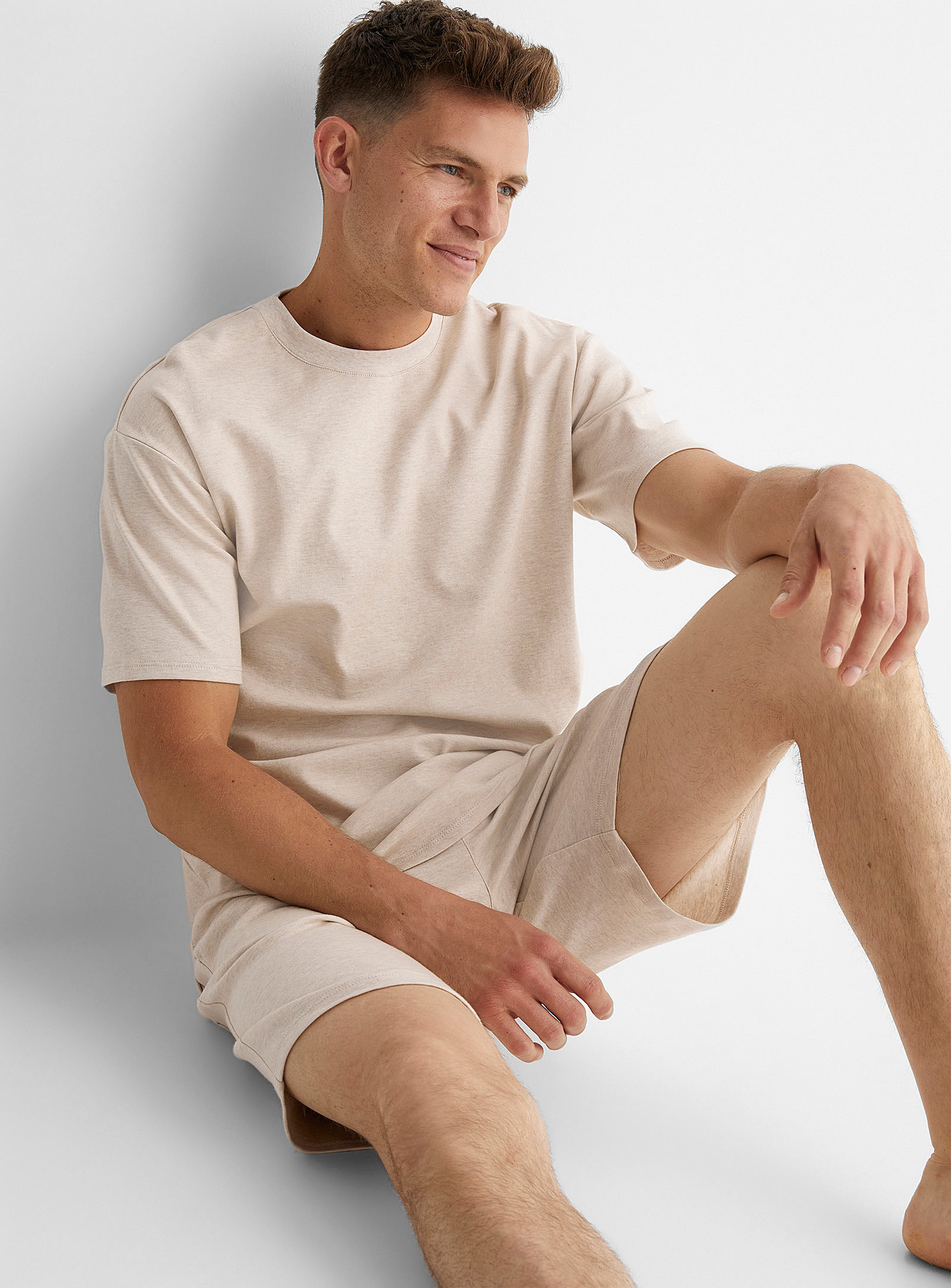 A person wearing a T-shirt and matching Bermuda shorts