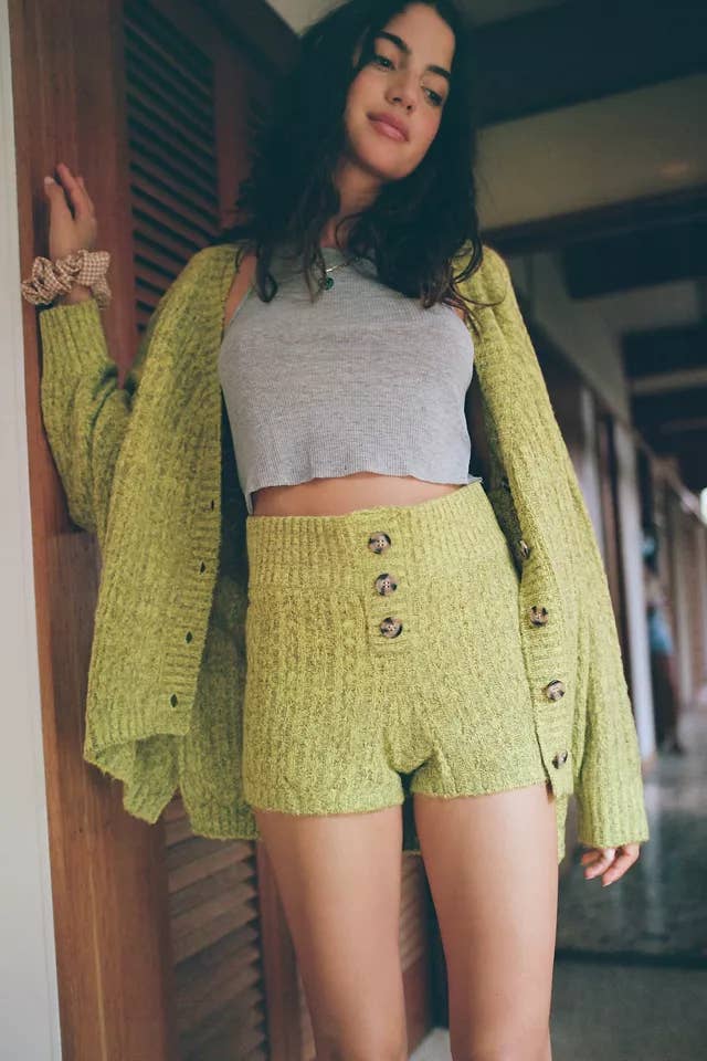 A person wearing a cardigan with matching knit shorts