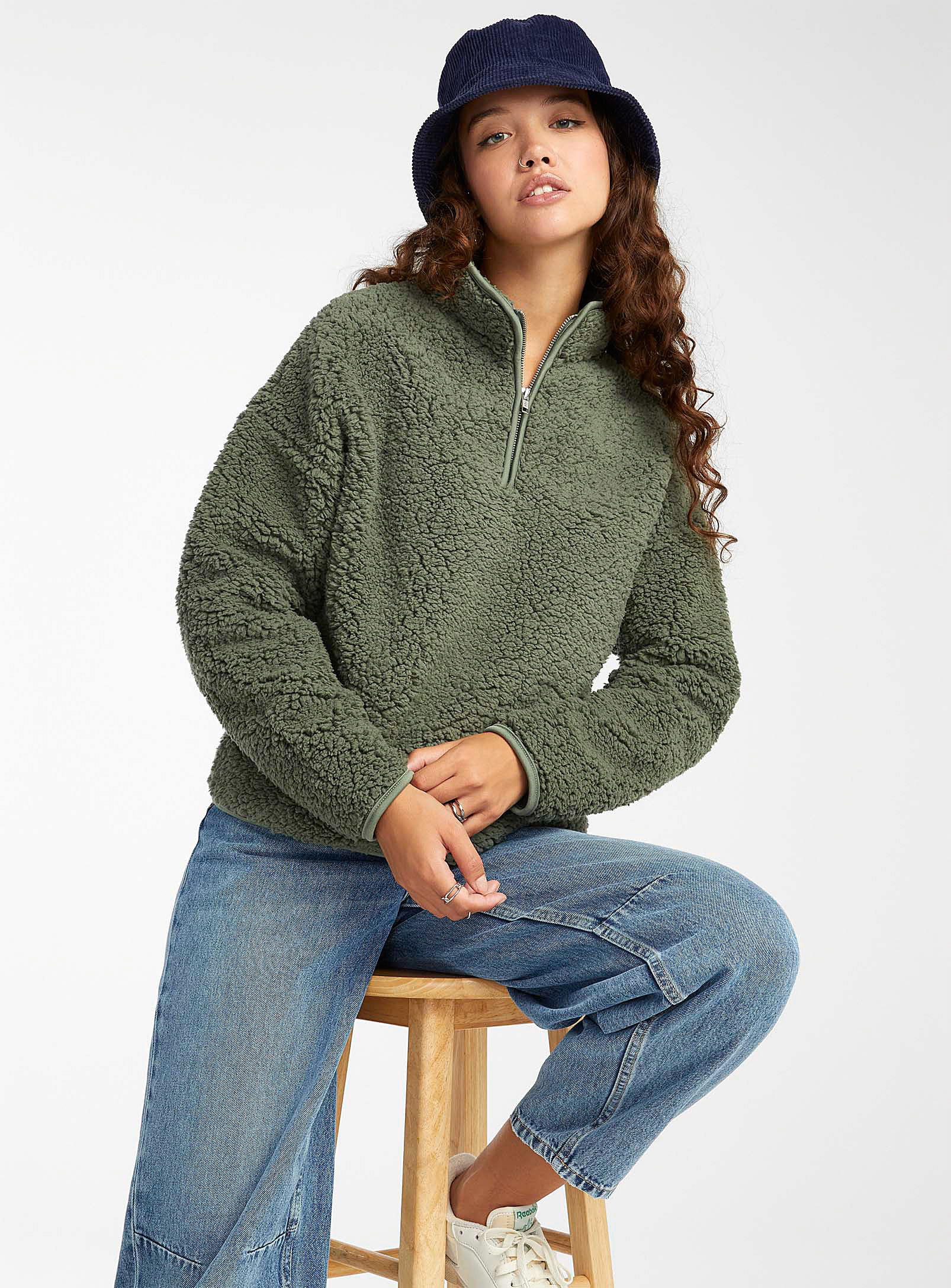 A person wearing a fuzzy sweatshirt with jeans