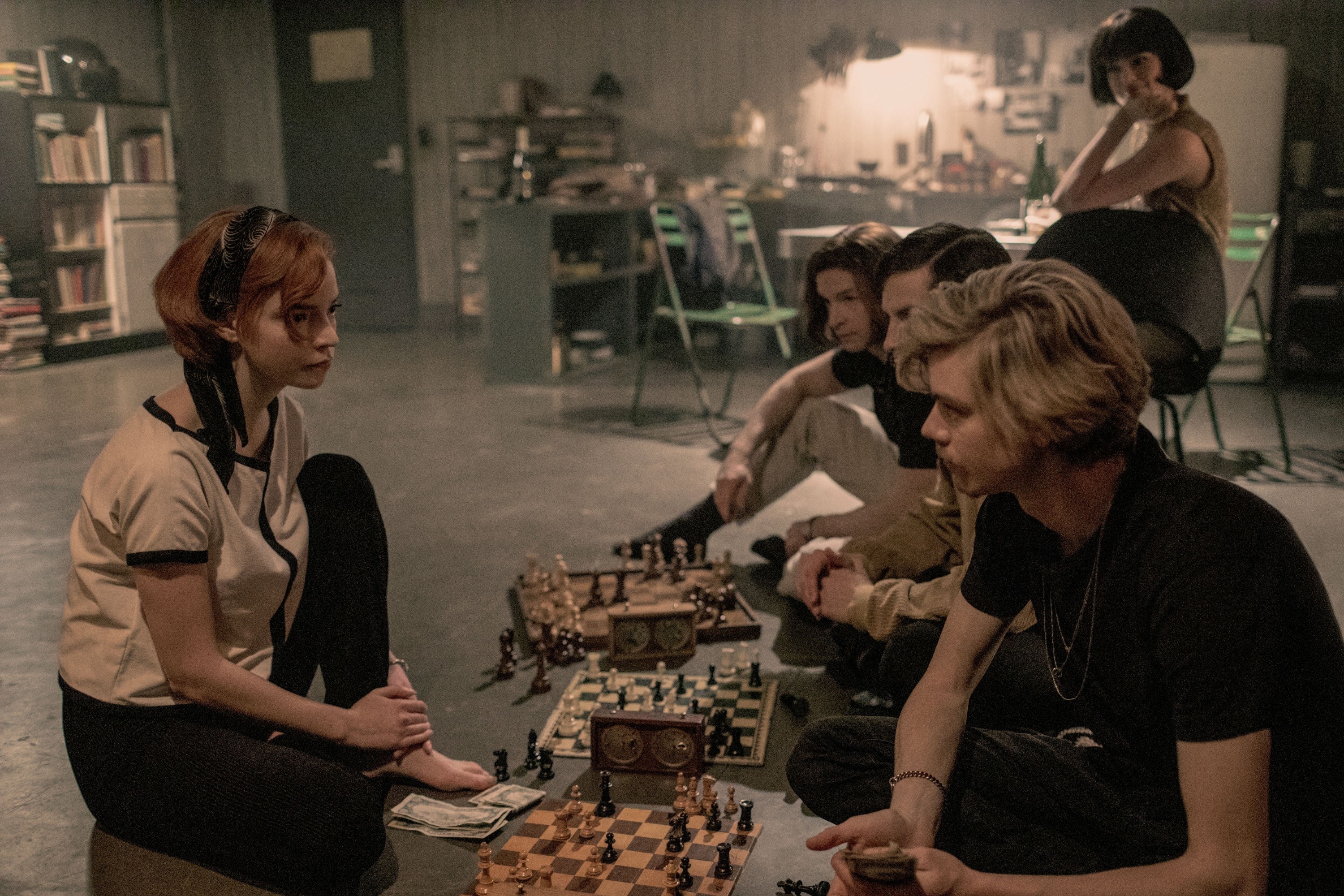 Anya sitting on the floor playing chess with several others