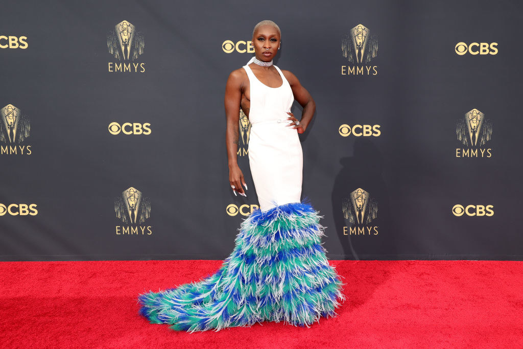 Cynthia Erivo on the red carpet in a white gown with a blue feathered bottom