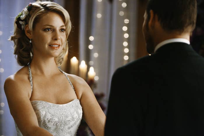 Heigl wears a wedding dress and holds a man&#x27;s hands while looking into his eyes