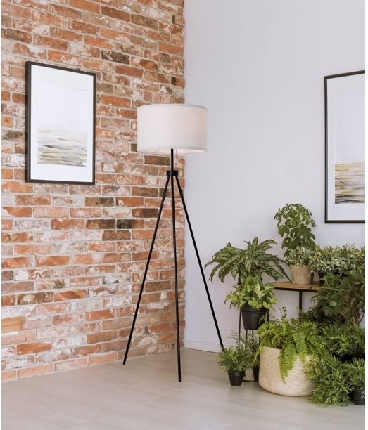 tripod floor lamp with black base and white lamp shade