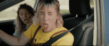 GIF of a woman coughing while driving