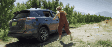 GIF of a woman kicking her car