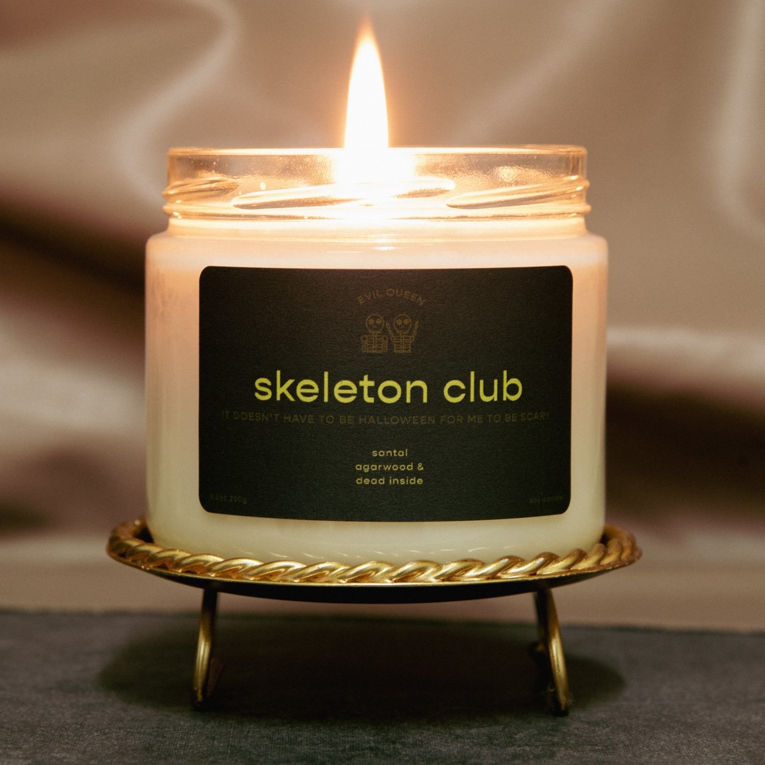 a candle with a black label that says &quot;skeleton club&quot; on it