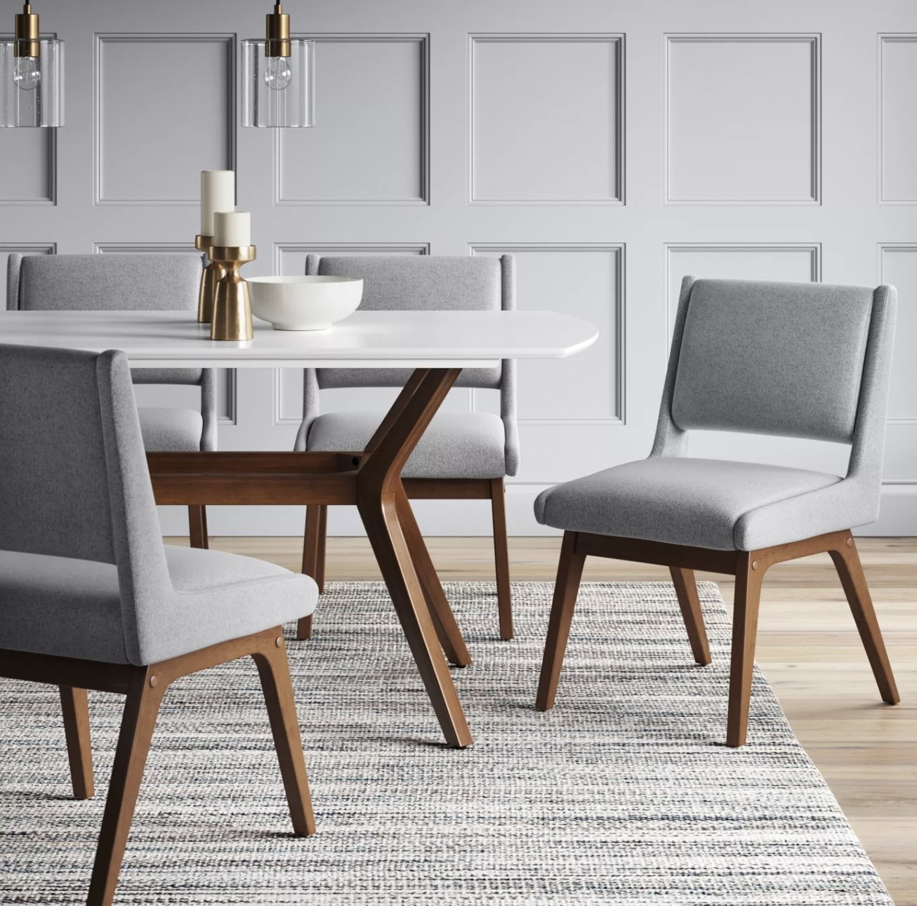 a grey upholstered dining chair with a backrest and tan wooden legs