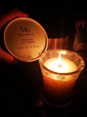 a reviewer burning the grey tea and musk candle