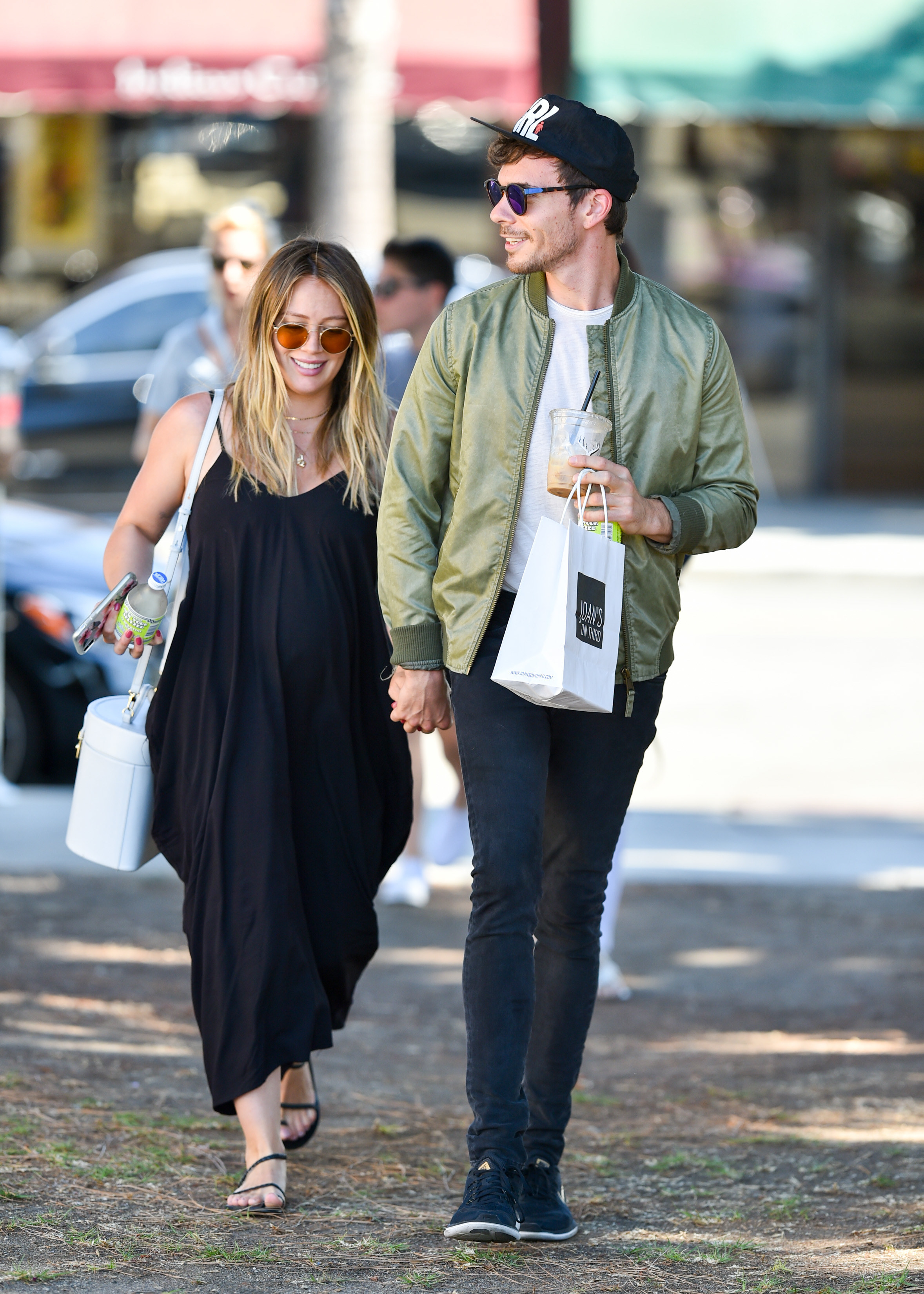 Hilary and Matthew holding hands while walking outdoors together and smiling